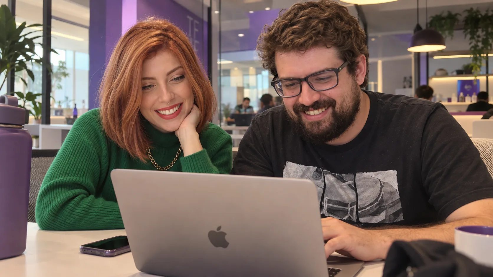 Gabriel e Flora, da Squadhouse, trabalhando juntos no notebook
